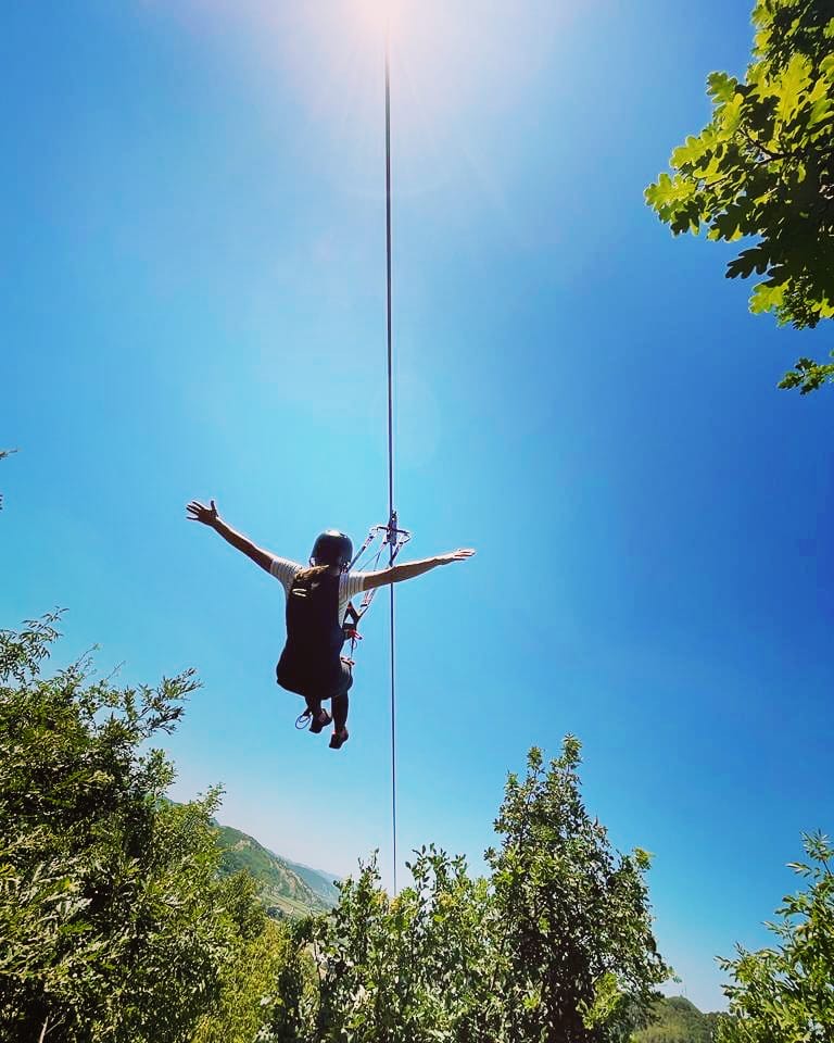 Rider hanging from cable with sun flare